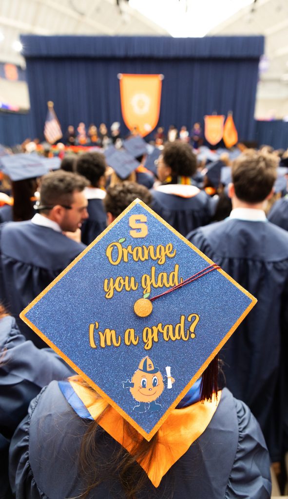 Top of a cap at graduation that says "Orange you glad I'm a grad?" 