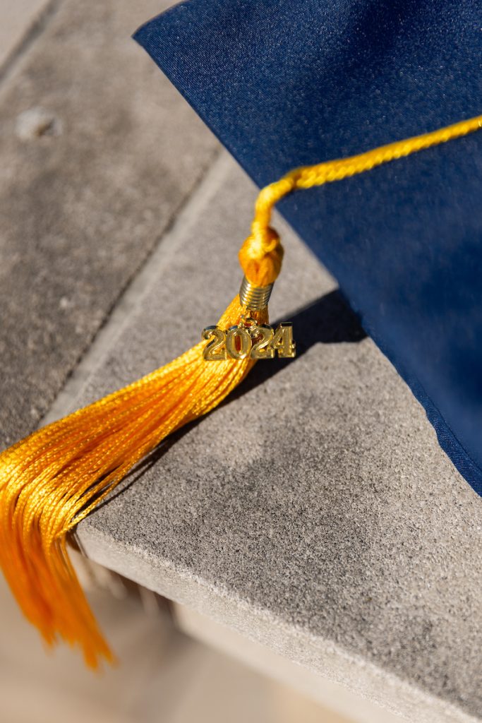 Cap and tassel sitting on a cement wall