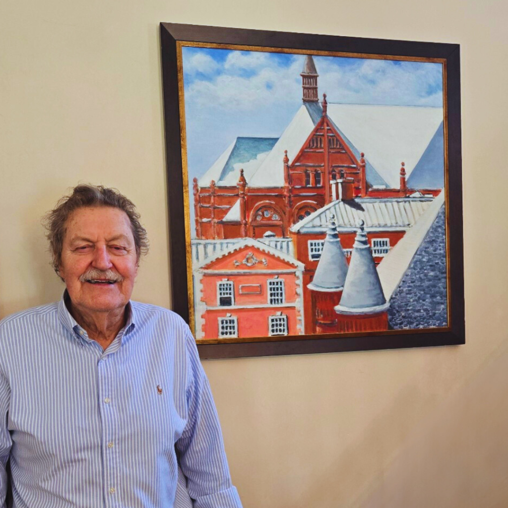 man standing next to painting of buildings on campus