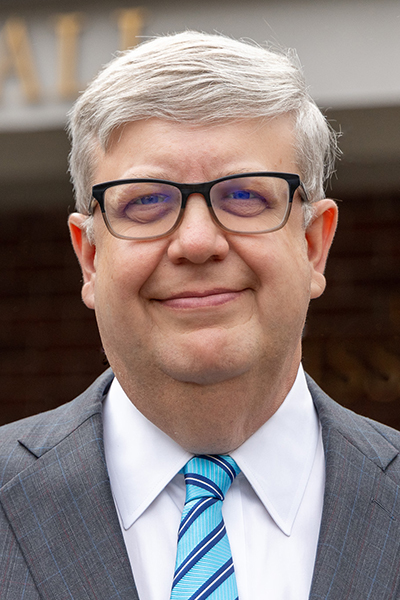 Headshot of man in glasses smiling