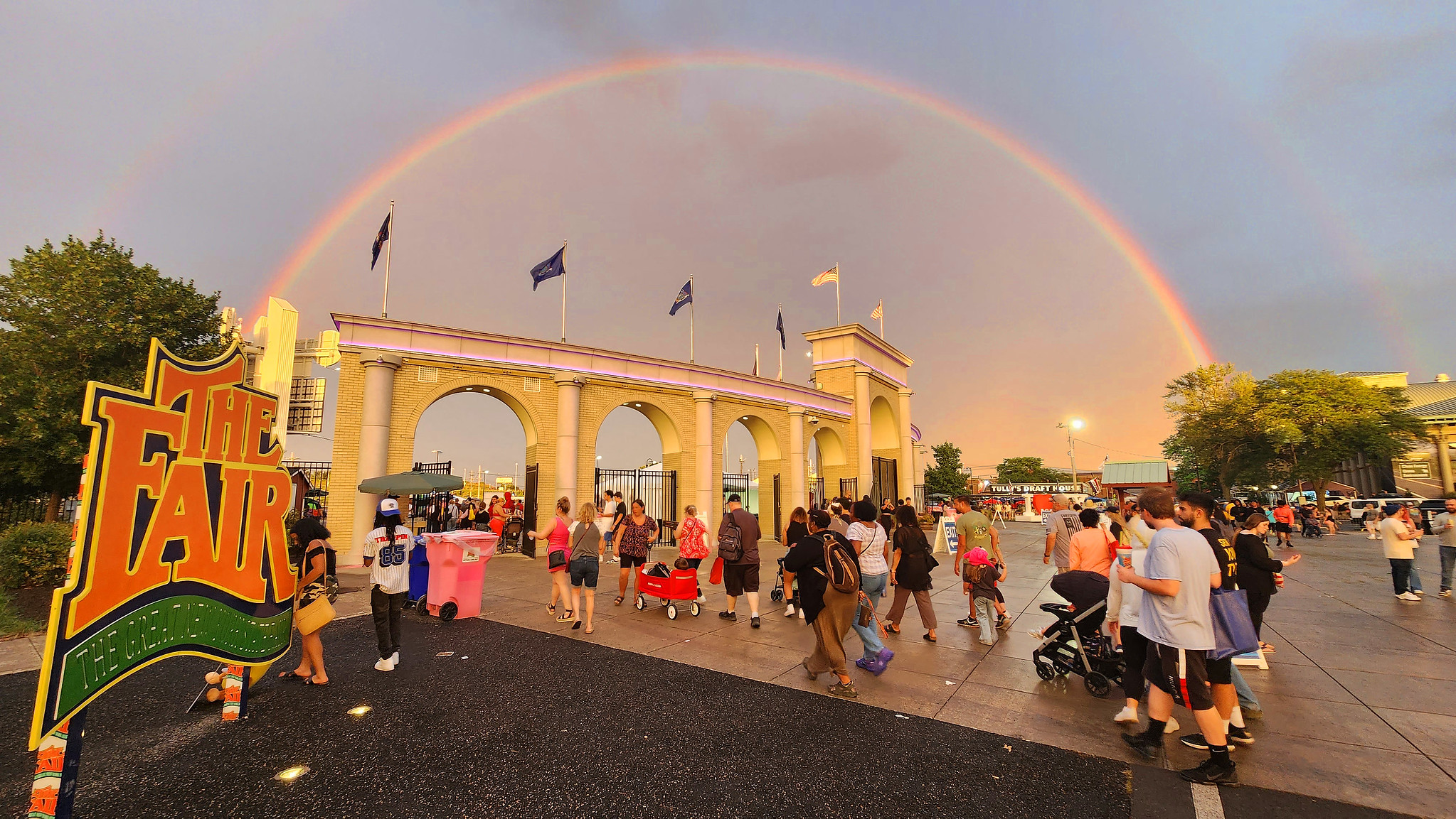 Rainbow over the new york state fair entrance and people walking around