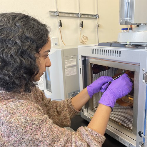 Bhattacharya performs maintenance on a gas chromatograph in laboratory