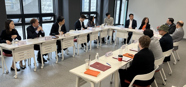 group of people seated around a u-shaped conference table