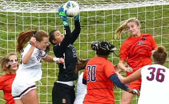 Lysianne Proulx with soccer ball in hands in front of net