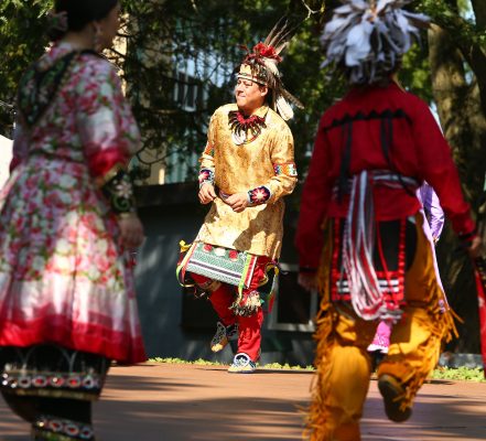 Individual in traditional native american clothing dancing. 