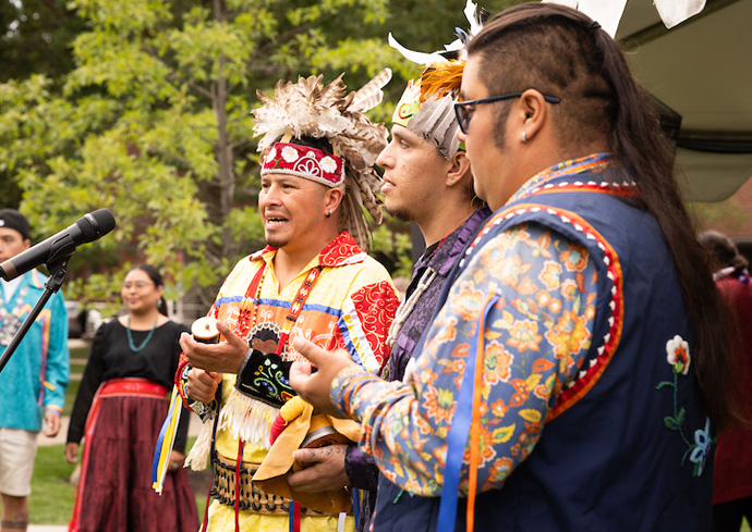 men in traditional indigenous clothing make music