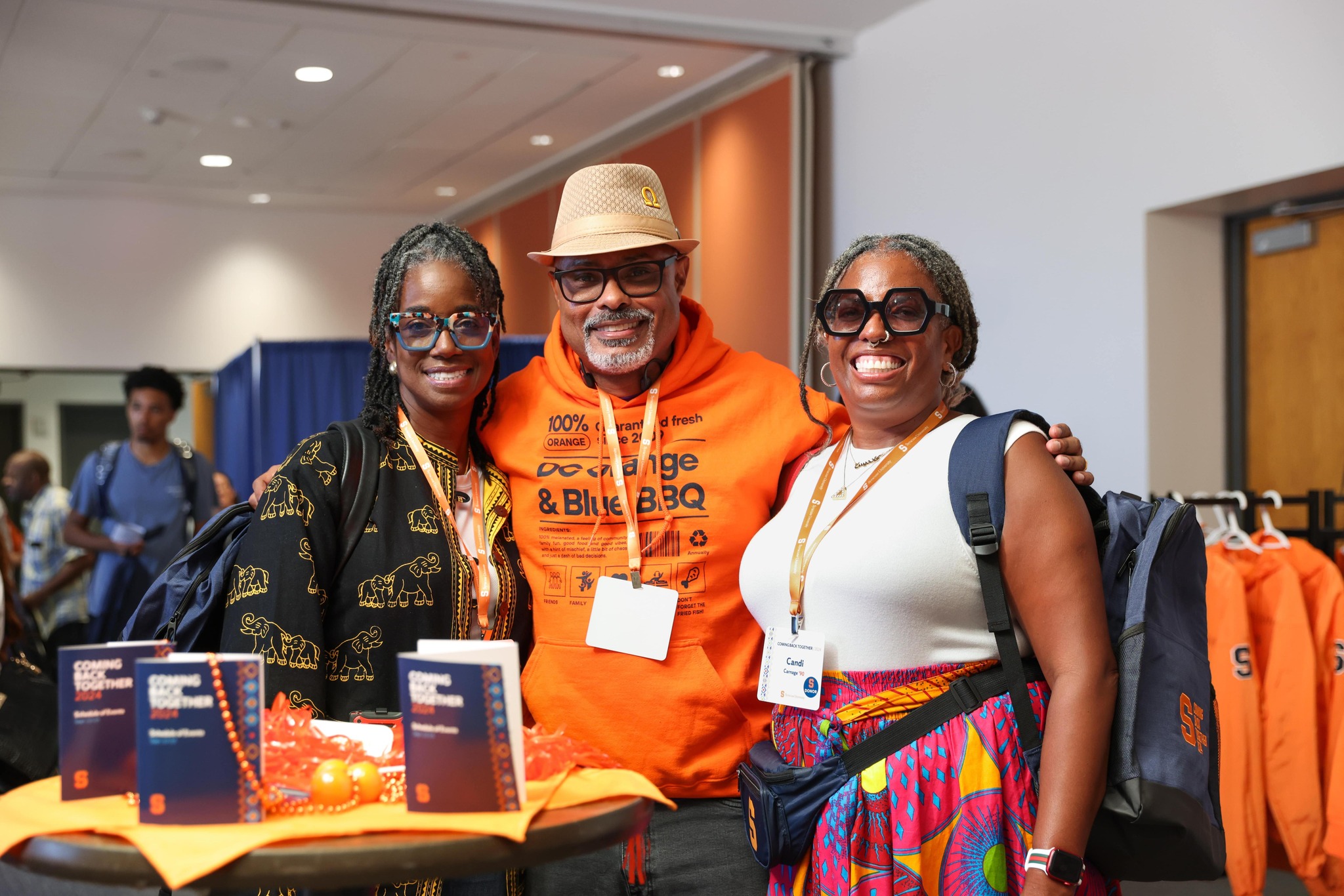 Three people standing together smiling at an event.