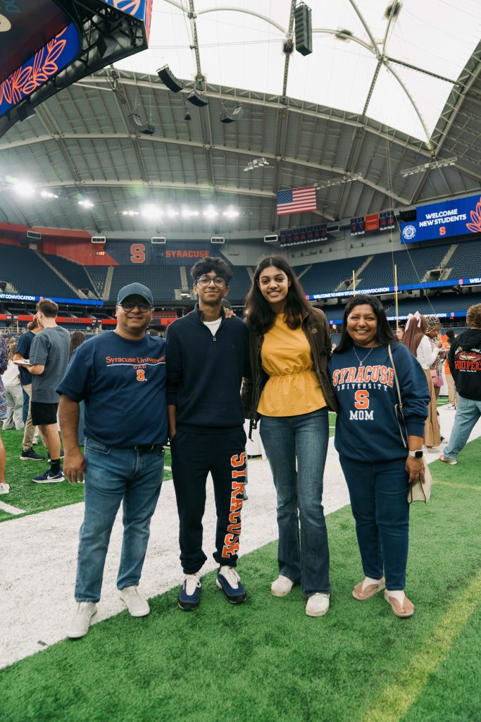 Four people standing together on the field in the JMA Dome.