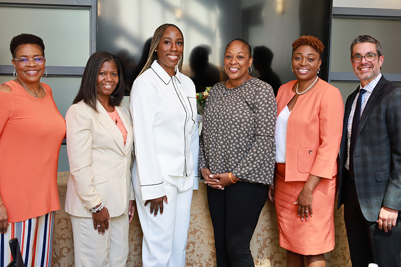 six individuals pose together during a Falk College/CBT panel discussion on women in sports