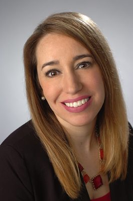 A woman smiles while posing for a headshot.