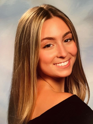 A woman smiles while posing for a portrait photograph.