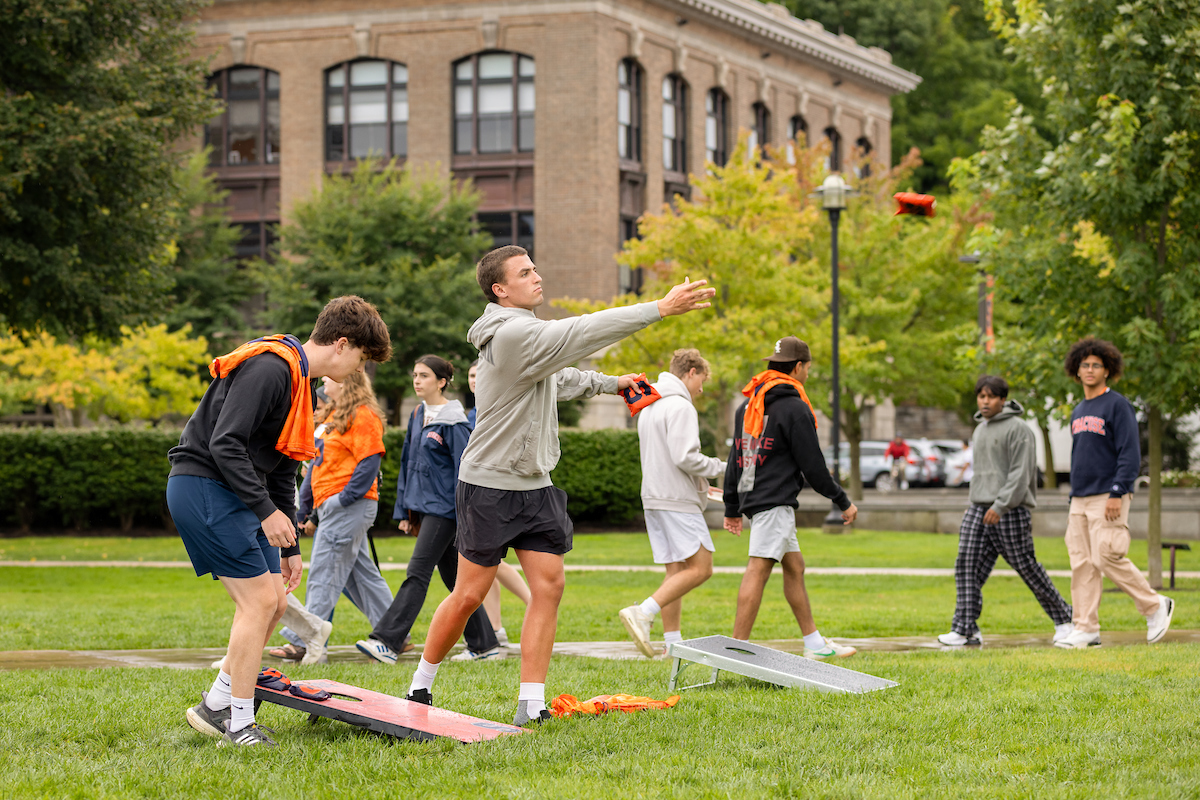 Students play cornhole on the quad. 