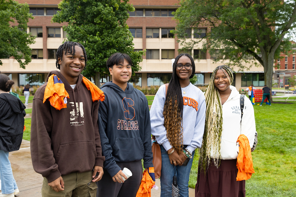 Four people standing together on the quad