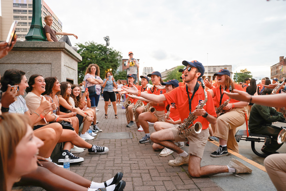 Members of the band perfroming for an audience in downtown Clinton Square