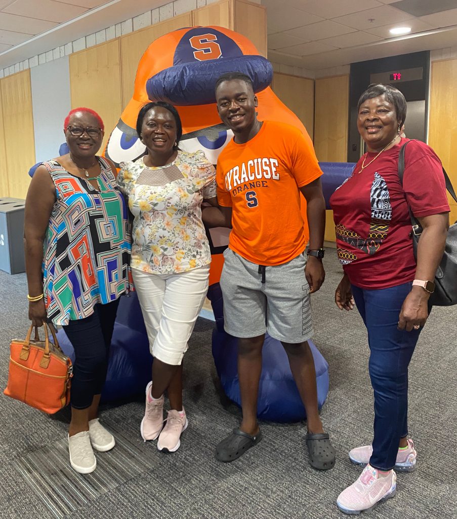 Four people standing together in front of a giant inflatable Otto.