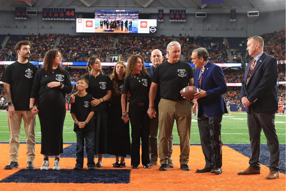 A family is given a game football on the JMA Wireless Dome field as a tribute to Jamieson R. Ritter.