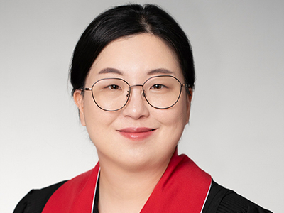 headshot of person in glasses smiling