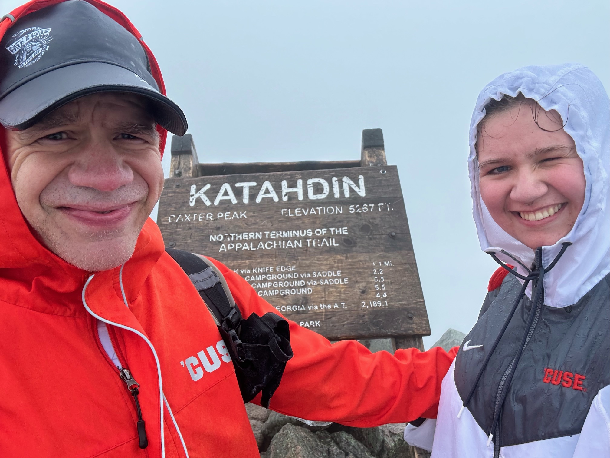 Two people in front of a sign that says Katahoin