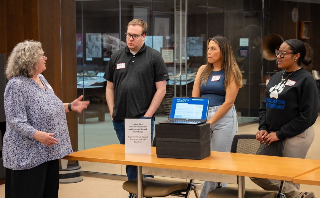 Professor and three students with information display