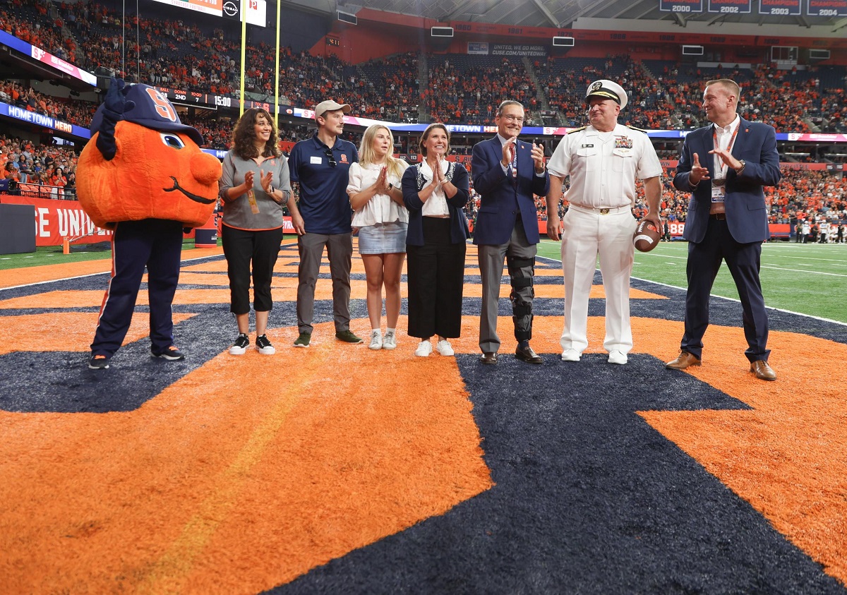 group of people standing on football turf in JMA Wireless Dome