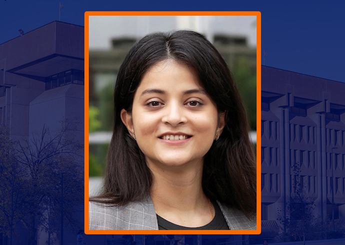 A woman smiles while posing for a headshot. An image of Bird Library is in the background.