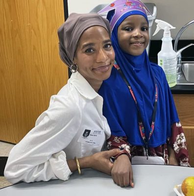 an adult and a child seated together at a table at a school