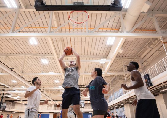 Four individuals play basketball at the Barnes Center at The Arch