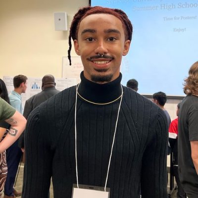 A student smiles while posing for a photo.