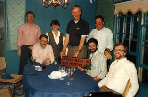 Students sit at a table with their professor.