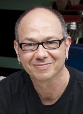 man with short hair and glasses smiling