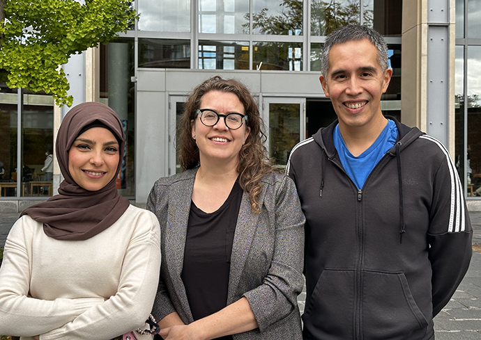 three people standing outside building