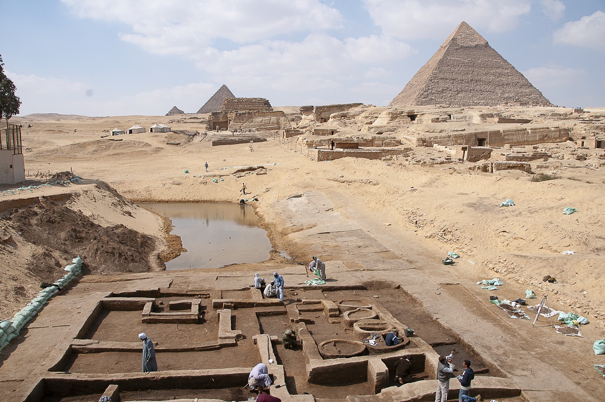 workers excavating an archeological site near a pyramid