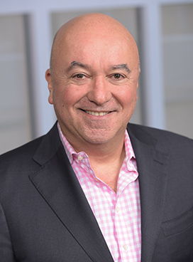 A man smiles while posing for a headshot.