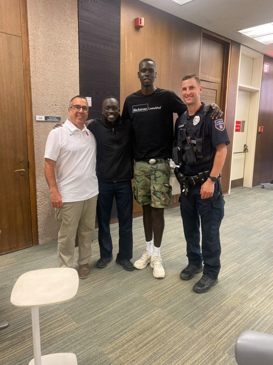 four people standing in lobby of library