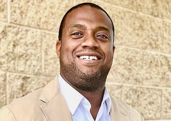 A man smiles while posing for a headshot.