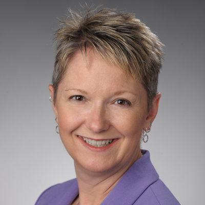 A woman smiles while posing for a headshot.