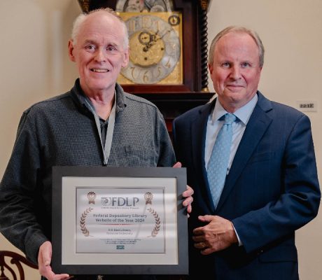 John Olson and David Seaman with the award presented to the Libraries by the GPO.