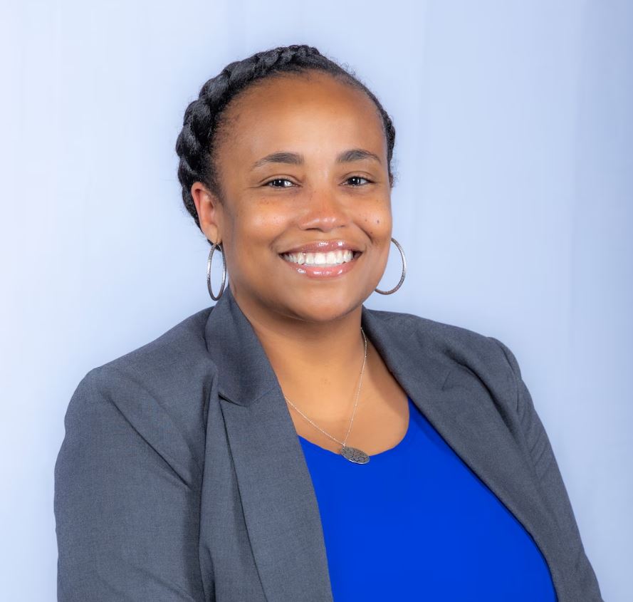 A woman smiles while posing for a headshot.