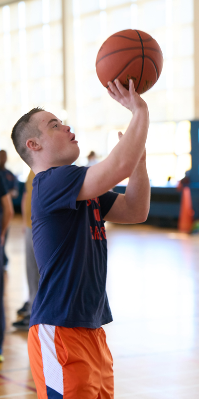 A man takes a shot on the basketball court inside the Women's Building on campus.