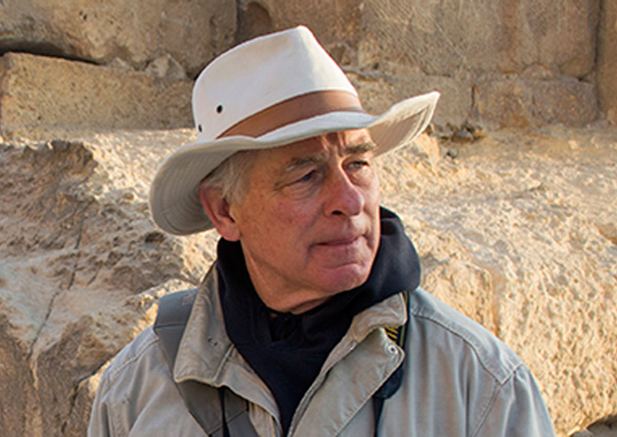 person wearing hat near rock outcropping