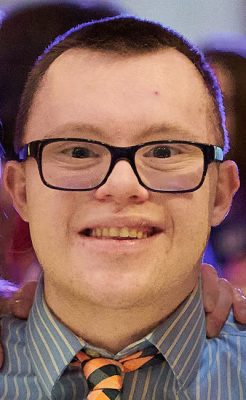 A student smiles while posing for a headshot.