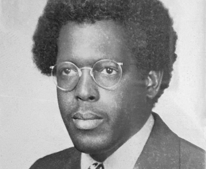 Black and white headshot of a man in glasses