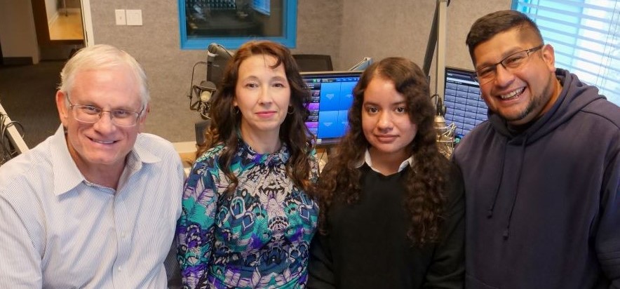 four person group in a radio station broadcasting booth