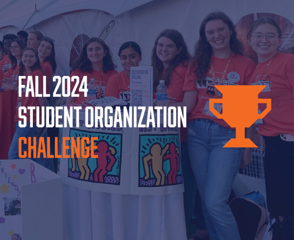 Graphic text "Fall 2024 Student Organization Challenge" with a trophy cup over a photo of students standing around tables outside a tent on the Quad