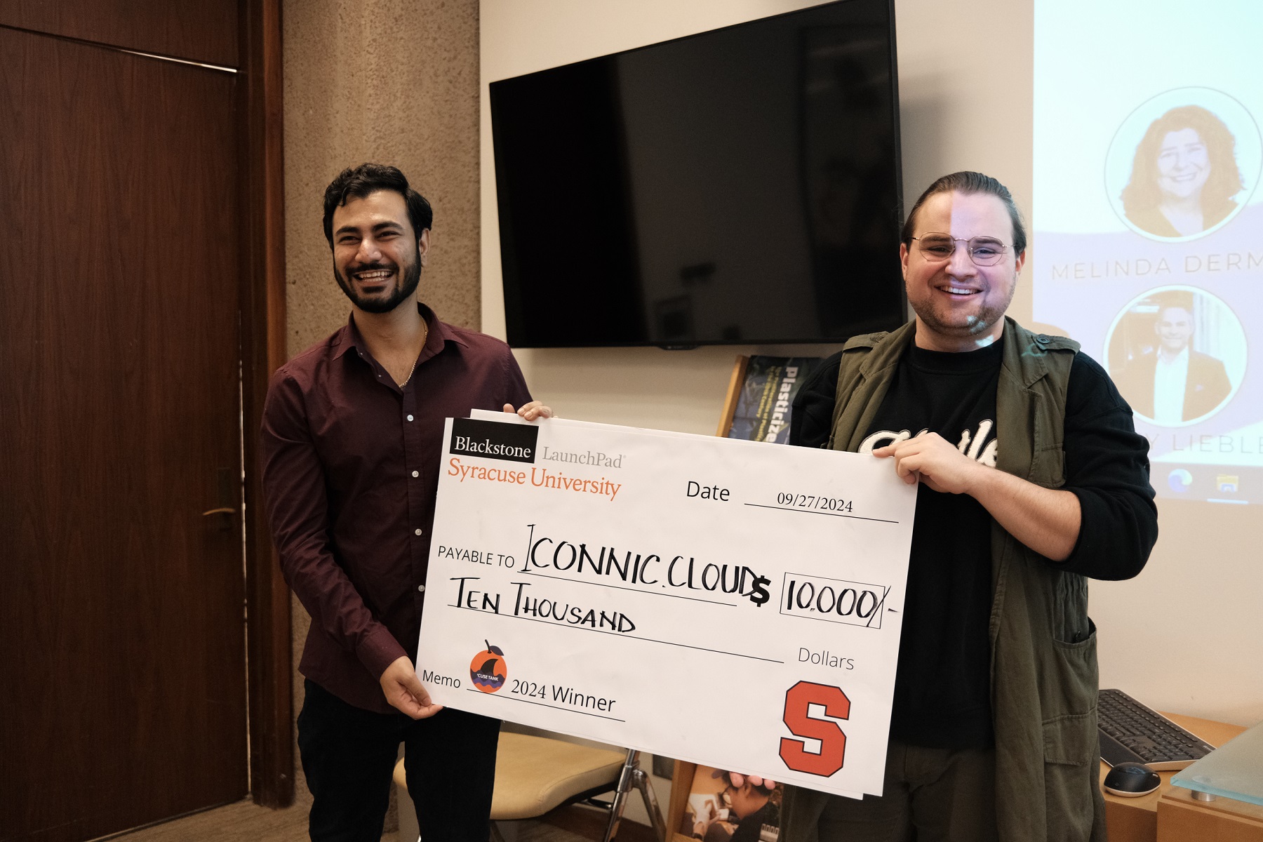 Two people holding an oversized check for $10,000