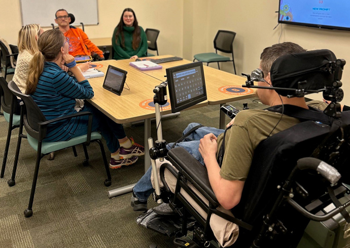 People gather in a room during a conversation club meeting.