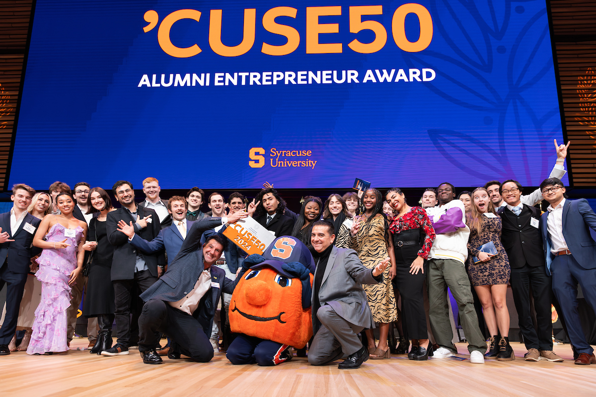 Group of Syracuse University students excitedly posing with the mascot at the 'Cuse50 Alumni Entrepreneur Award event.