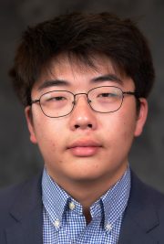 young man with fringe bangs and thin eyeglasses