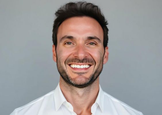 A man smiles while posing for a headshot.