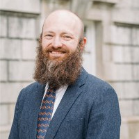 A man smiles while posing for a headshot.